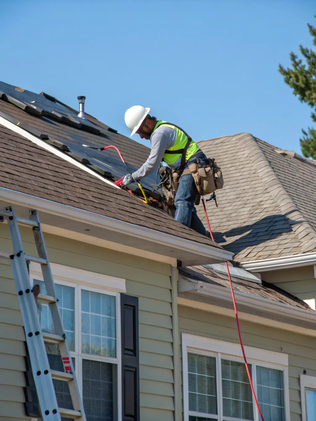 A professional roofer installing a new asphalt shingle roof on a suburban home, ensuring durability and weather resistance.